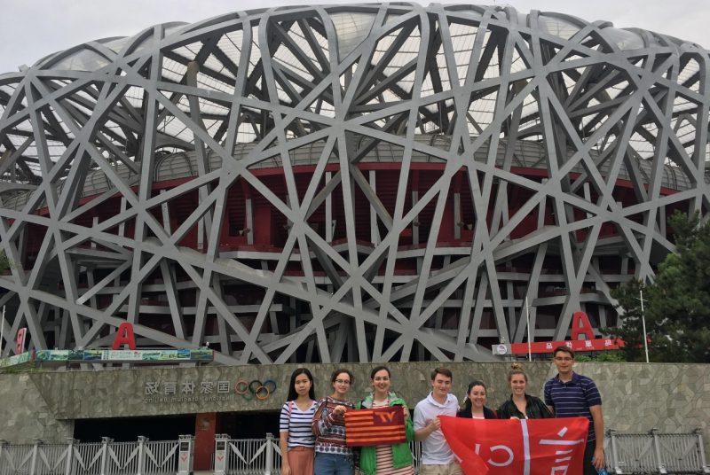 中国北京，弗吉尼亚理工大学的学生们站在奥林匹克体育场前